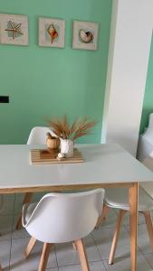 mesa de comedor blanca con 2 sillas blancas en Apulia Home, en Zapponeta