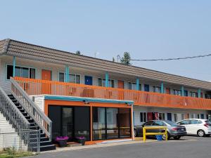 un edificio naranja con coches estacionados en un estacionamiento en Howard Johnson by Wyndham Spokane, en Spokane