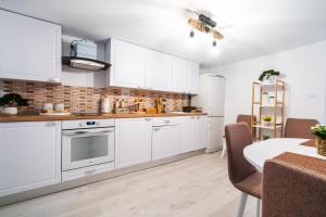a kitchen with white cabinets and a table with chairs at River House in Bran