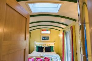 a bedroom with a bed with a skylight at Plumcot Halt by Bloom Stays in Canterbury