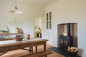 eine Küche mit einem Tisch und einem Kamin in der Unterkunft East Cottage by Bloom Stays in Dungeness