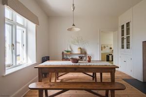 ein Esszimmer mit einem Holztisch und einer Bank in der Unterkunft East Cottage by Bloom Stays in Dungeness + 21 Fotos