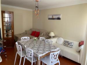a living room with a table and chairs and a couch at Bela vista apartamento Estoril Cascais in Estoril +20 photos