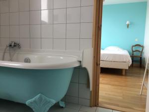 a bathroom with a bath tub and a bedroom at Hotel Particulier Richelieu in Calais