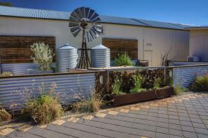 einer Windmühle vor einem Gebäude mit Pflanzen in der Unterkunft Comfort Inn & Suites Augusta Westside in Port Augusta