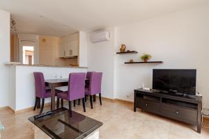 a living room with a table and purple chairs at Soling 80 in La Manga del Mar Menor