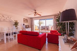 een woonkamer met 2 rode stoelen en een tafel bij Star Alfa in La Manga del Mar Menor