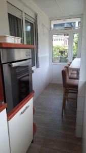 een keuken met een fornuis, een tafel en een raam bij Apartmani Tomovic in Sutomore