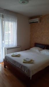 een slaapkamer met een bed met twee handdoeken erop bij Apartmani Tomovic in Sutomore