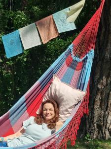 a girl laying in a hammock in a tree at ŐzikeLak24 in Szigetmonostor