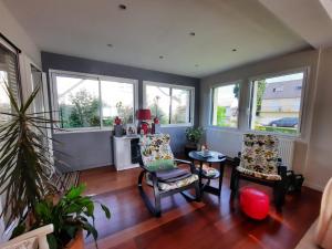 a living room with two chairs and a table and windows at 19,Avenue John Kennedy in Breteil