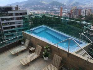 
a large swimming pool with a balcony overlooking a city at Café Hotel Medellín in Medellín
