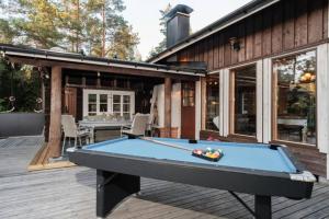 a pool table on the deck of a house at Sirpa's Artistic Nuuksio Retreat with Heated Pool in Espoo