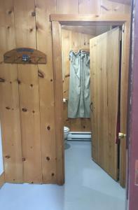een badkamer met een toilet en een deur naar een kamer bij Riverfront Rustic Cottage in Durham Bridge
