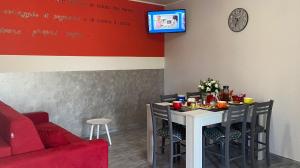 a dining room with a table and a red wall at A Casa Nostra in Pietramelara