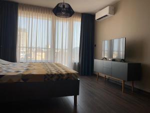 a bedroom with a bed and a flat screen tv at Studio Via Pontica in Varna City