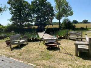 huśtawka w parku z trzema ławkami w obiekcie Herrenhaus Gut Neuruppersdorf w mieście Timmendorfer Strand