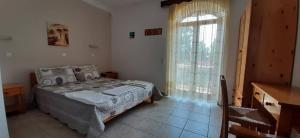 a bedroom with a bed and a large window at TRADITIONAL HOUSE ALEPIS IN AREOPOLIS in Areopoli