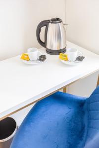 a tea kettle and two cups on a counter at Hotel Mondego in Coimbra