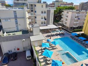 una vista sul soffitto di una piscina con sedie e ombrelloni di Hotel Golf ***S a Bibione