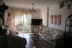 - un salon avec un canapé et une télévision dans l'établissement Apartamento en primera línea de playa, con vistas a la playa y con wifi, à Roquetas de Mar