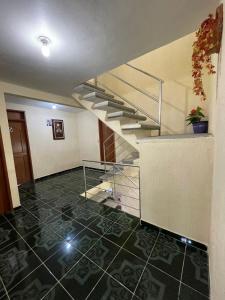 um corredor com uma escada e piso em azulejo em Casa de Huéspedes May em Ixtapan de la Sal