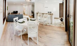 cocina y sala de estar con mesa blanca y sillas en Casa Miño, en Ourense