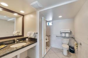 a bathroom with a sink, toilet, and bathtub at Best Western Plus Beach Resort in Fort Myers Beach