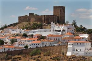 una ciudad con un castillo en la cima de una colina en Alojamentos Oasis, en Mértola