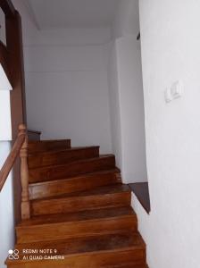 a stairway with wooden stairs in a house at Apartmani Aleksandar in Nevesinje