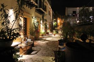 a courtyard with chairs and potted plants at night at Torre Bennistra in Scopello