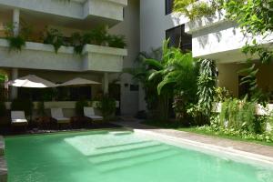 a swimming pool in front of a building at Che Suites Tulum in Tulum