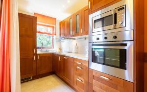 a kitchen with wooden cabinets and stainless steel appliances at Apartman Neda -Vantacici Malinska in Vantačići