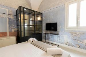 a bedroom with a bed and a tv on a wall at Palazzo Balsamo in Gallipoli