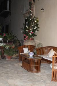 a patio with tables and chairs and a flower arrangement at Torre Bennistra in Scopello