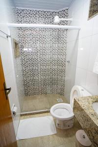 a bathroom with a shower with a toilet and a sink at Hotel Diamantte in Cachoeiro de Itapemirim