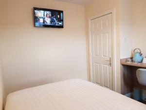 a bedroom with a bed and a tv on the wall at Bella Room with free minibar tea&coffee in Dublin
