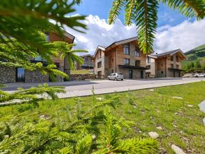 uma casa com um carro estacionado em frente a uma estrada em Chalet Alaskit Jasná em Demanovska Dolina