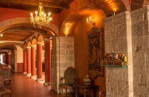 a hallway in a building with a chandelier at Hotel Monasterio in Sucre