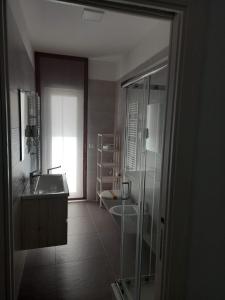 y baño con ducha acristalada y lavamanos. en Casa MIMI en Matera