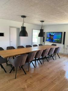 luksus spahus i skagen في سكاغن: قاعة اجتماعات كبيرة مع طاولة وكراسي طويلة