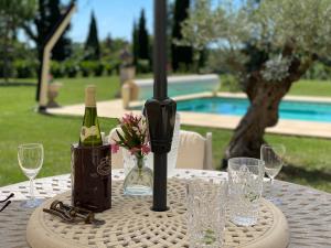 een tafel met een fles wijn en glazen erop bij Amity. Exclusive poolside garden apartment in Sarlat-la-Canéda