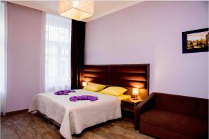 a bedroom with a bed with a purple blanket on it at Domus Apartments in Prague