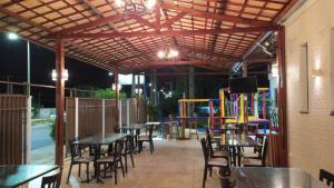 a patio with tables and chairs and a playground at Pousada Lagoa Seca in Juazeiro do Norte