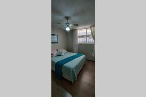 um quarto com uma cama e uma ventoinha de tecto em Margate Boulevard - Superb Secure Apartment em Margate