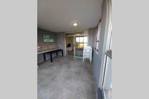 an empty room with a table and a desk at Margate Boulevard - Superb Secure Apartment in Margate