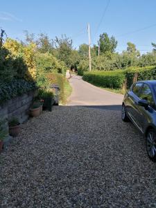 a driveway with a car parked on a gravel road at Riverside in Chepstow