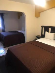 ein Hotelzimmer mit 2 Betten und einem Fenster in der Unterkunft COSTA MAR in Ensenada