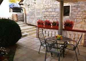 a table and chairs on a patio with flowers at Apartment Dolic in Livno