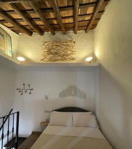 Un dormitorio con una cama con sábanas blancas y techos de madera. en Casita Beatriz - by Casa del Patio en Estepona